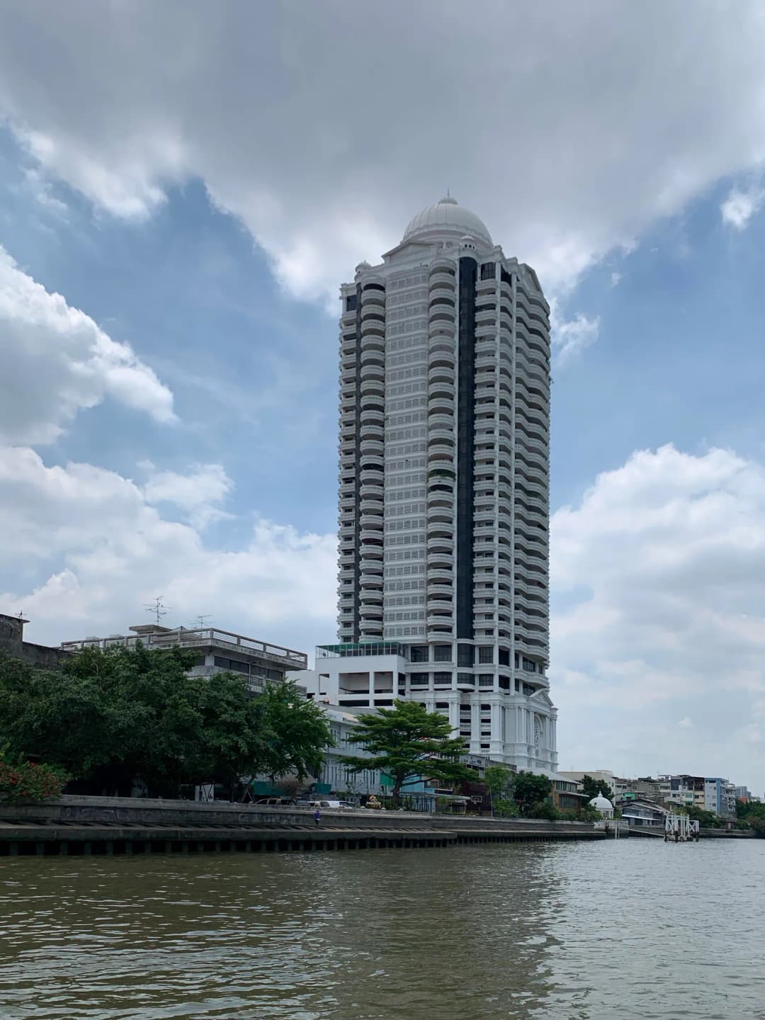 Tall white residential condominium tower beside the Chao Phraya River in Bangkok